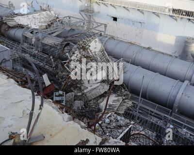 Trümmer vor den Überresten der Einheit 4 oberen Ebenen in das Kernkraftwerk Fukushima Daiichi 18. Dezember 2012 in Okuma, Japan. Die Pflanze erlitten eine katastrophale Kernschmelze im März 2011. Stockfoto