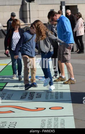 Große Monopoly board Einrichten auf dem Trafalgar Square in London Spiele Festival. Die öffentlichkeit spielen auf der Platine mit einem Handy app. Menschen spielen Stockfoto