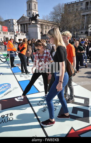 Große Monopoly board Einrichten auf dem Trafalgar Square in London Spiele Festival. Die öffentlichkeit spielen auf der Platine mit einem Handy app. Menschen spielen Stockfoto