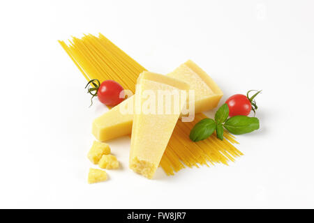 zwei Keile von frischem Parmesan-Käse, Gemüse und Spaghetti auf weißem Hintergrund Stockfoto