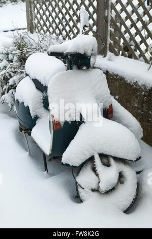 Eine alte Vespa moped oder Motorrad bei einem Haevy Winter mit Schnee bedeckt fallen. Stockfoto