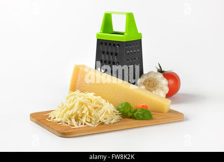 Reibe und Haufen von geriebenem Parmesan auf Holzbrett Stockfoto