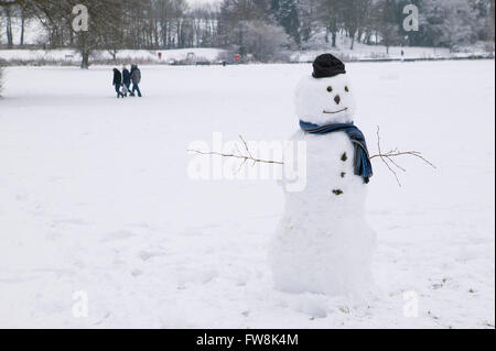 Ein Schneemann im frisch gefallenen Schnee von einem britischen Winter allein in einem Park in Gloucestershire Stadt von Cirencester im Vereinigten Königreich gemacht. Stockfoto