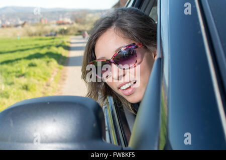 Frau, die selbst bei einem Autospiegel auf einem roadtrip Stockfoto