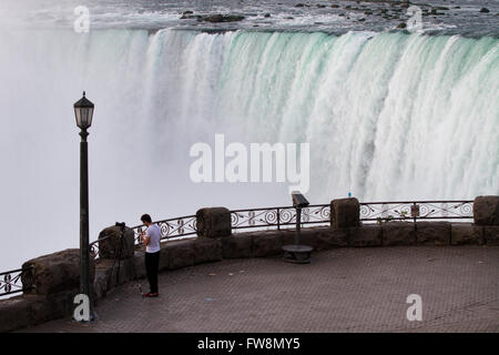 Ein Tourist fotografiert die kanadischen Horseshoe Fälle früh morgens in Niagara Falls Ontario, auf Dienstag, 28. Juli 2015. Stockfoto