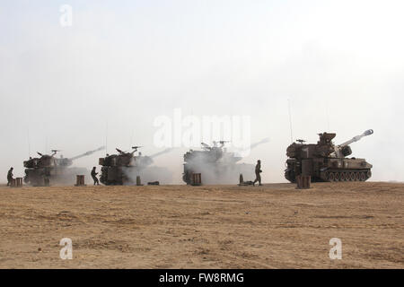 Reihe von M109 Selbstfahrlafetten in der Negev-Wüste, Israel abfeuern. Stockfoto