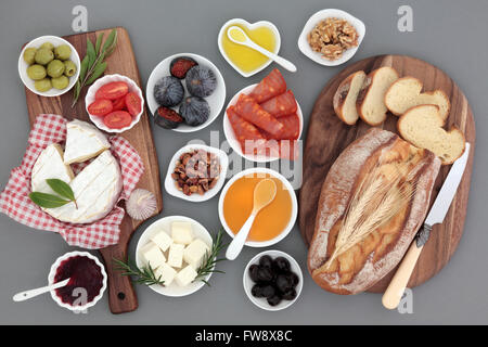 Picknick Essen Stilleben mit Fleisch, Käse, Obst, Gemüse, Marmelade, Honig und Kräutern mit rustikalen Französisch Brotlaib auf Ahorn-Boards. Stockfoto