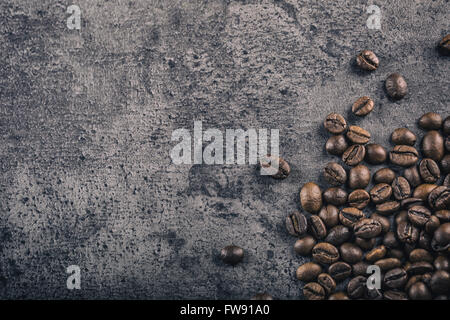 Kaffee. Gerösteter Kaffeebohnen verschüttete frei auf einen konkreten Hintergrund. Stockfoto