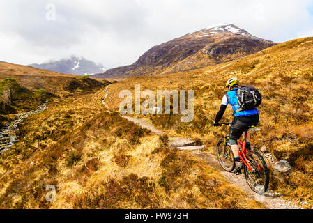 Mountainbiker auf Moorland über Glen Coulin in Torridon Highland Schottland. Beinn Liath Mhor rechts und Fuar Tholl im Nebel Stockfoto