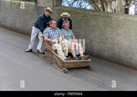 FUNCHAL, PORTUGAL-März 19 Rodelbahn Fahrer mit Schlitten mit Tauchen Touristen am 19. März 2016 in Monte Funchal, Portugal. Das ist Stockfoto