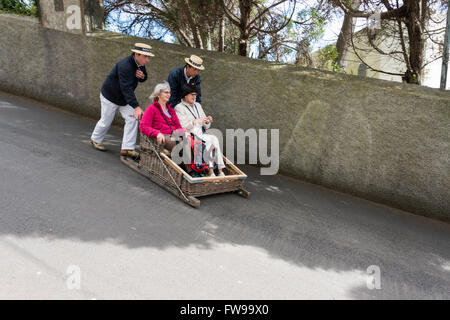 FUNCHAL, PORTUGAL-März 19 Rodelbahn Fahrer mit Schlitten mit Tauchen Touristen am 19. März 2016 in Monte Funchal, Portugal. Das ist Stockfoto