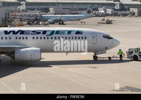 Ein Westjet Flugzeug wartet geladen werden vor der Abreise aus Pearson International Airport in Toronto, Ontario am 7. Mai 2015. Stockfoto