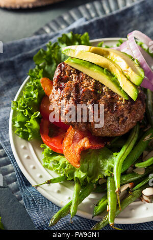 Frisch gegrillte Paleo Hamburger mit Gemüse und Speck Stockfoto