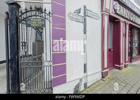 Ein Wandbild und ein schwarzes Eisen Tor an einer Hauptstraße in der Innenstadt von Ennis, County Clare, Irland. Stockfoto