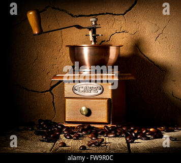 Holz Kaffee Mühle und Getreide Kaffee in der Nähe von Lehm Wand Stockfoto