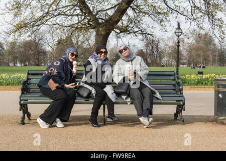 Muslimische Frauen genießen ein Eis und einen ruhigen Nachmittag im Hyde Park, London, UK Stockfoto