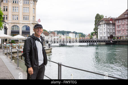 Happy Tourist in Luzern mit Brücke, Fluss Reuss und Stadt hinter Stockfoto