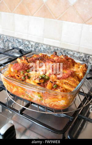 fleischige gebackene Rigatoni Withtasty Füllung in einer Pfanne Ofen aus Glas auf einem Kochfeld Stockfoto