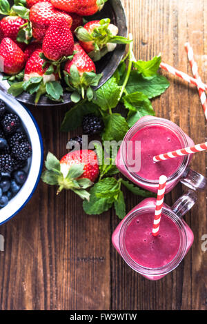 Herstellung von frischen Beeren-Smoothie Diät, Zutaten und Glas mit lebendigen Stroh von oben Stockfoto