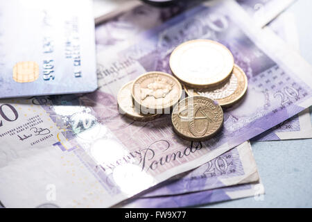 Britische Pfund-Münzen und Banknoten auf Tisch mit Taschenrechner Stockfoto