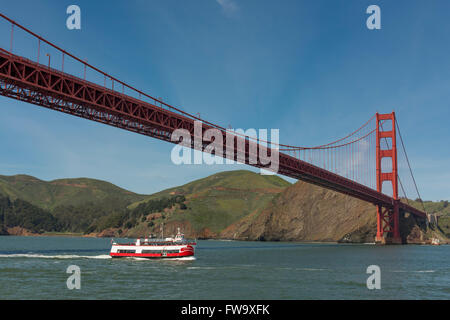 Die Golden Gate Bridge mit Ausflugsschiff vorbei darunter, in der Nähe von San Francisco, Kalifornien, USA Stockfoto