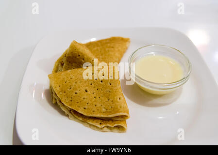 Pfannkuchen mit Kondensmilch auf Platte Stockfoto
