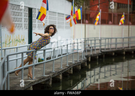 Schöne junge asiatische Frau mit Sonnenbrille auf dem Fluss-Ufer. Stockfoto