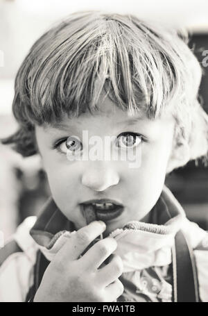 Porträt des kleinen Jungen Essen, Blick in die Kamera Stockfoto