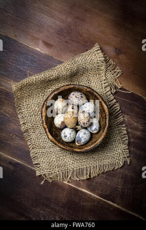 Frische Bio Wachteleier in Keramikschale auf Leinen Lappen. Natürliches Licht, selektiven Fokus, Draufsicht Stockfoto