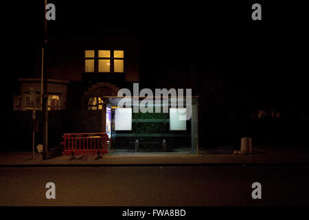 Einen leeren Bus stop in Belgien in der Nacht, hell durch künstliches Licht. Stockfoto