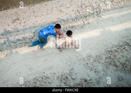 Zwei fröhliche Kinder, die auf ein Spielzeugauto in der manikgonj Bezirk, Dhaka, Bangladesch, Asien © jahangir Alam onuchcha/alamy Stockfoto