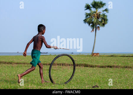 Ein Junge spielt mit Fahrrad Reifen in der vola Bezirk, barishal, Bangladesch, Asien © jahangir Alam onuchcha/alamy Stockfoto