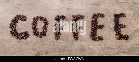 Inschrift Kaffee aus gerösteten Bohnen auf Holz Textur gelegt Stockfoto