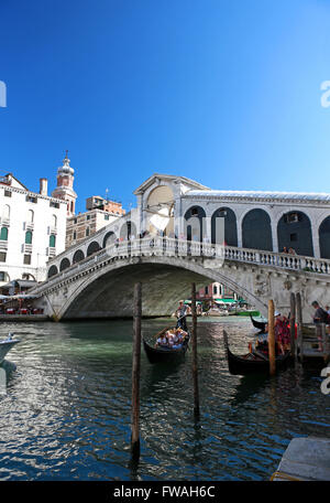 Eine Gondel schwebt unter der Rialto Brücke - Ponte di Rialto, Venedig, Italien. Beliebte Touristenattraktion in der venezianischen Stadt am Meer gebaut. Stockfoto