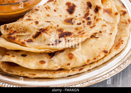 Indische geschichteten Paratha Roti Kerala Porotta mit Hühnchen-Curry auf der Seite Stockfoto