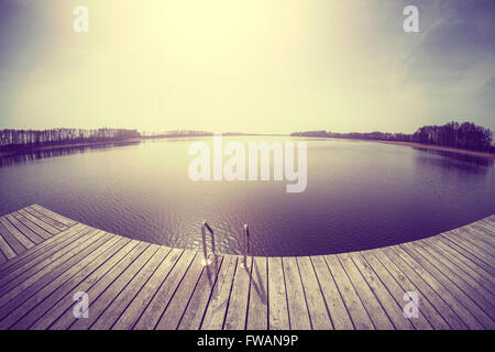 Vintage getönten fisheye-Objektiv Bild eines hölzernen Pier, See Osiek im Frühjahr, Polen. Stockfoto