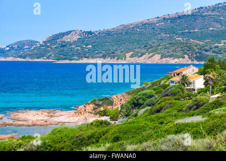 Sommer Küstenlandschaft der Insel Korsika. Kleinen Azure Bucht mit Futter Haus auf felsigen Küste. Piana Region, Frankreich Stockfoto