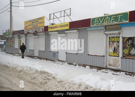 Charkiw, Ukraine. 19. Januar 2016. Ein Mann geht vorbei an geschlossenen Geschäften auf dem zentralen Marktplatz in Charkow, Ukraine, 19. Januar 2016. Foto: Soeren Stache/Dpa/Alamy Live News Stockfoto