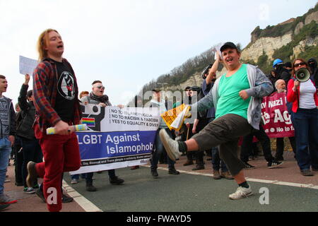 Dover, Kent, Großbritannien. April 2016. Eine vielfältige Gruppe von Demonstranten versammelt sich im Freien, um gegen Islamophobie, Rassismus und Faschismus zu protestieren. Auf einem prominenten Banner steht „LGBT gegen Islamophobie“ neben Botschaften der Gleichheit und Liebe. Regenbogenflaggen und südafrikanische Flaggen sind sichtbar. Die Teilnehmer halten Schilder, darunter „No Nazi“, und setzen sich aktiv mit der Menge auseinander, wobei einer ein Megaphon verwendet und der andere in energischem Ausdruck nach vorne tritt. Ein rechtsextremer einheitsmarsch durch das Stadtzentrum, angeführt von der rechten Gruppe Südostallianz. Penelope Barritt/Alamy Live News. Stockfoto
