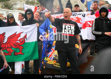 Dover, Kent, UK. 2. April 2016. Ganz rechts Demonstrant verbrennt der europäischen Flagge. Antifaschistische Gruppen, einschließlich London Antifaschisten, Kent Antirassismus Netzwerk (KARN) und vereinen gegen Faschismus (UAF), nehmen auf die Straße von Dover nach Zähler zeigen eine ganz rechts Einheit Marsch durch die Innenstadt unter der Leitung von der rechten Flügel-Gruppe Süd-Ost-Allianz, die die Nationale Front (NF) und English Defence League (EDL) umfasst. Penelope Barritt/Alamy Live-Nachrichten Stockfoto