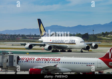 Virgin America A320 mit Singapore Airlines A380 im Hintergrund auf dem Rollfeld in Los Angeles Airport Stockfoto