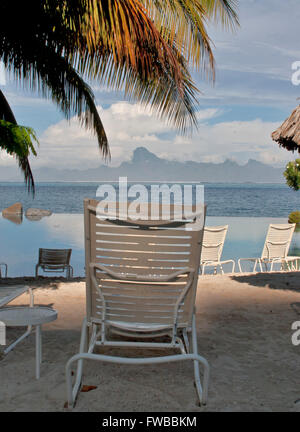 Tahiti, Französisch-Polynesien, Liegestühle am Strand in Papeete, Thaiti mit den Bergen von Moorea im Hintergrund. Stockfoto