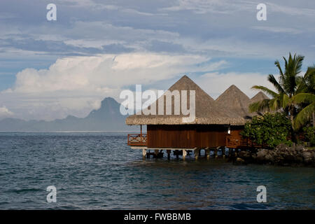Tahiti, Französisch-Polynesien, Urlaub Bungalows entlang einer Lagune in Papeete, Thaiti mit den Bergen der Insel Moorea Stockfoto