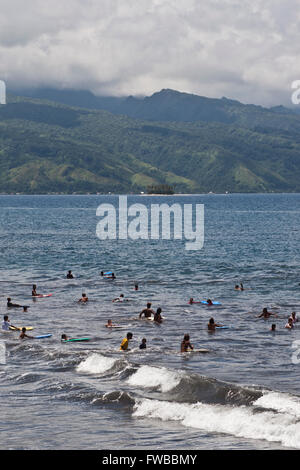 Tahiti, Französisch-Polynesien, Badegäste in der Brandung an einem Strand auf Tahiti. Stockfoto