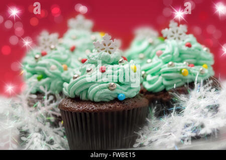 Weihnachts-Muffins auf rotem Hintergrund dekoriert Stockfoto