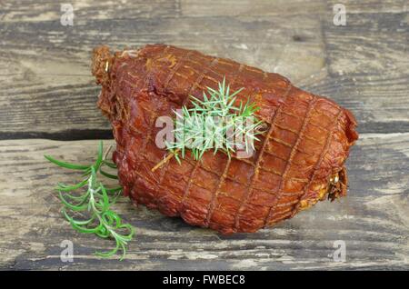 geräucherter Schinken mit Wacholder auf Holzbrett Stockfoto