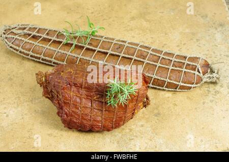 zwei Fleisch Wurst und Schinken auf Terrakotta-Hintergrund Stockfoto