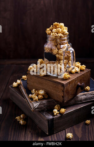 Etwas Süßes Popcorn in Glas platziert auf einem Stapel Bücher Stockfoto