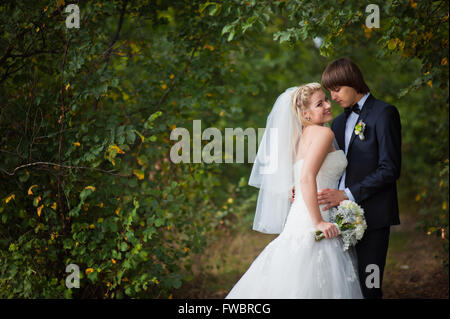 Braut und Bräutigam stehen im park Stockfoto
