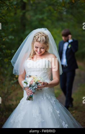 Elegante Braut und Bräutigam zusammen posiert im Freien an einem Hochzeitstag Stockfoto